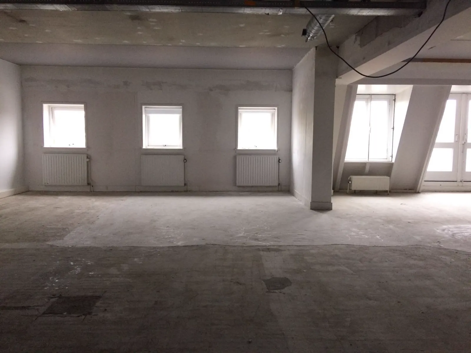 Kale betonvloer met reparatieplekken, voor het egaliseren